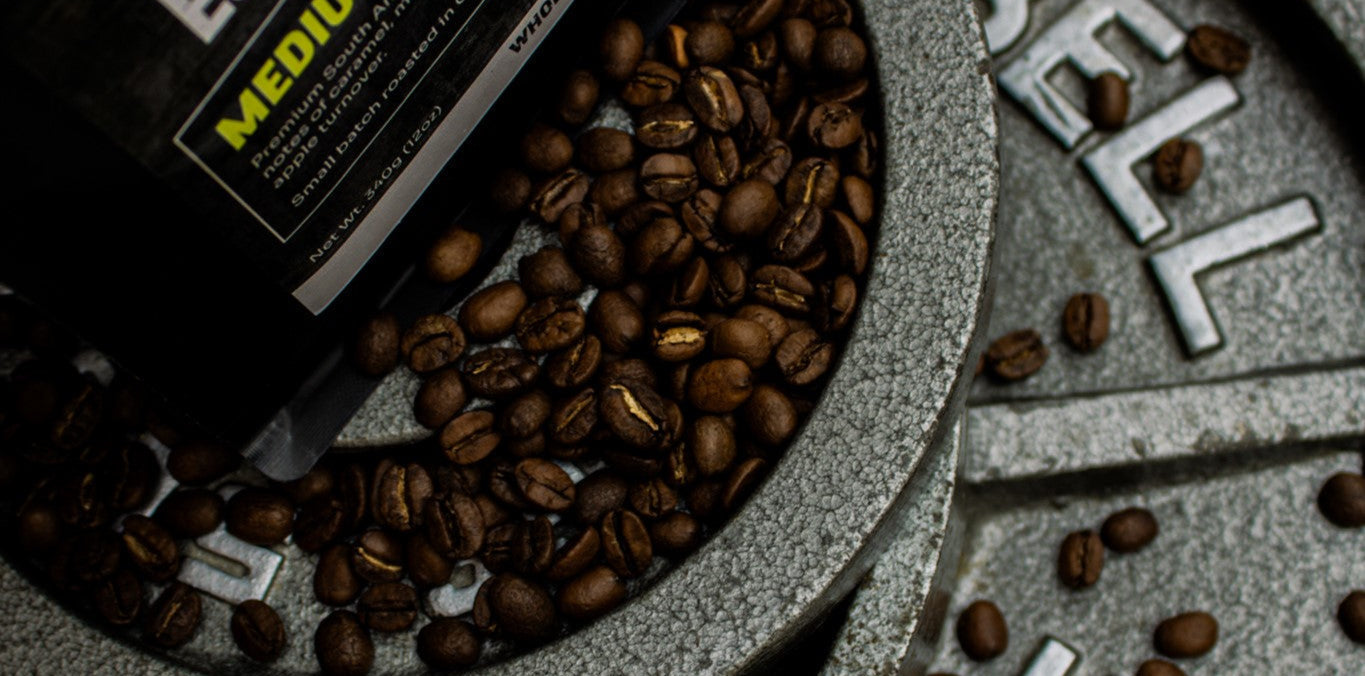 Coffee beans and a coffee bag on a metal weight scale